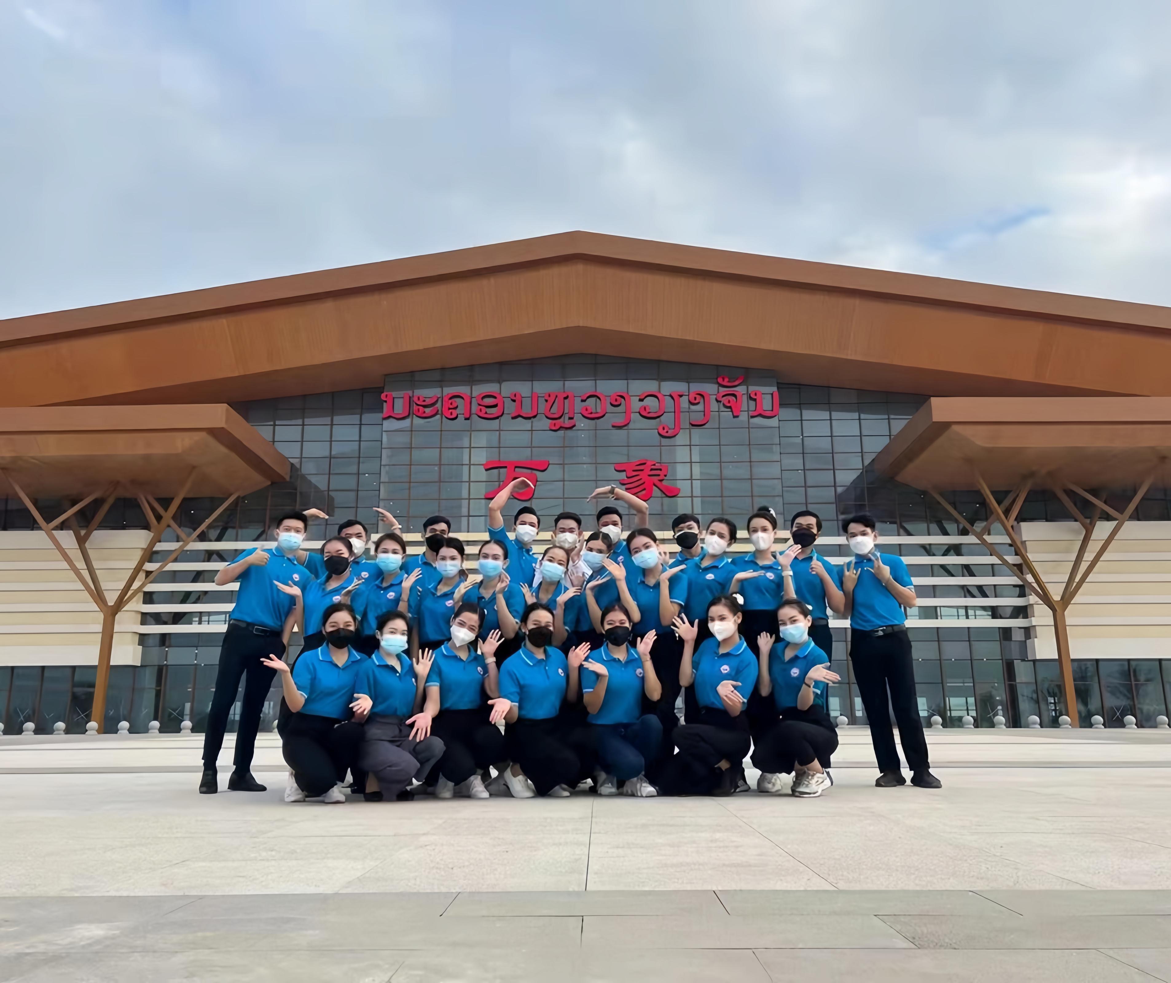 學生上崗前在老撾萬象高鐵站前合影（其中5人為貴陽職業(yè)技術(shù)學院培訓班學生）。 貴陽職業(yè)技術(shù)學院供圖